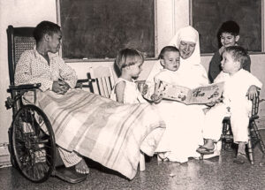 Franciscan Sister of the Poor Patricia Holly reads to children at St. Elizabeth Hospital in Dayton, Ohio, 1960s