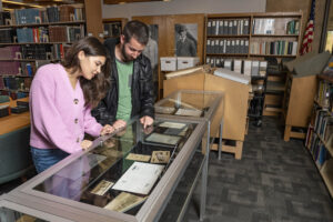 A photograph of the research spaces at Wright State University Special Collections and Archives. A man and woman stand in front of an exhibit case.
