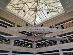 A photograph of the 1903 Wright Brothers airplane replica. It is suspended from the ceiling and this photograph was taken from below.